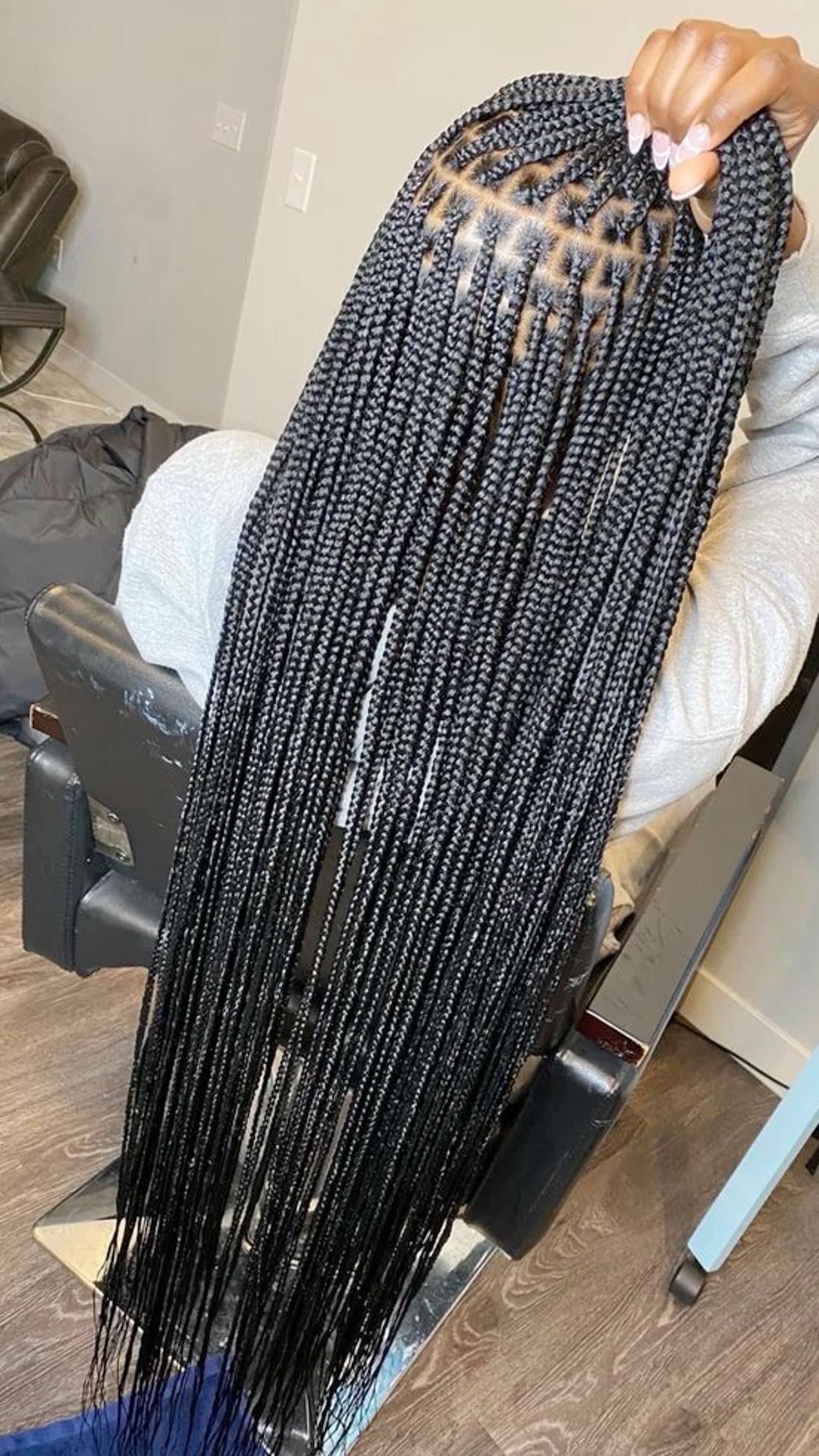 Stylist sectioning and braiding a client's hair with clean, even parts